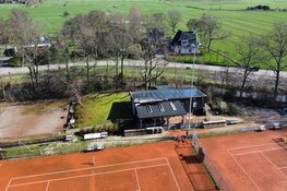 Schade door brand bij tennisvereniging bij daglicht goed zichtbaar door dronefoto's